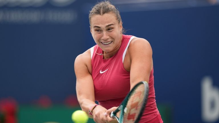 Aryna Sabalenka, of Belarus, hits a return to Amanda Anisimova,...