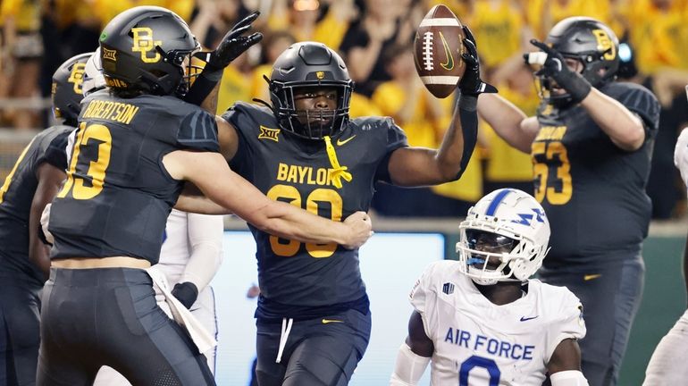 Baylor running back Bryson Washington, center, reacts with quarterback Sawyer...