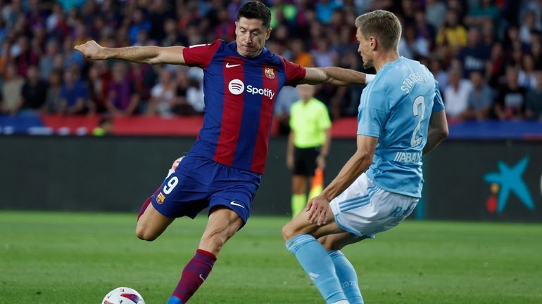 Barcelona's Robert Lewandowski, left, prepares to shoots past Celta's Carl...