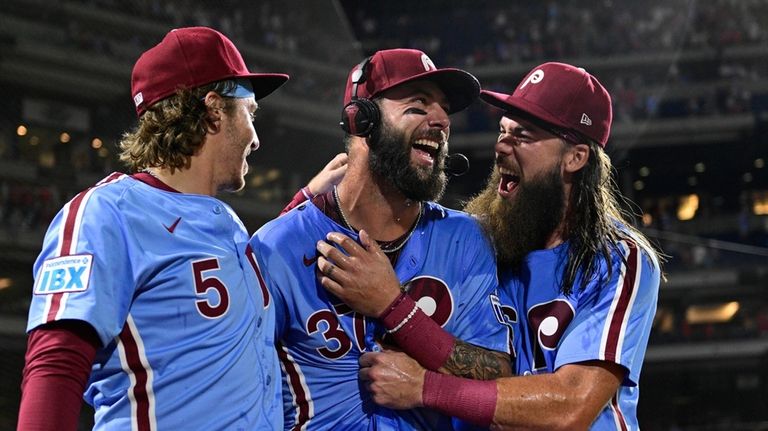 Philadelphia Phillies' Weston Wilson, center, celebrates after he was doused...