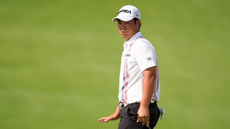 Tom Kim, of South Korea, reacts to his putt on...