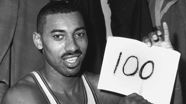 Wilt Chamberlain holds a sign reading "100" in the dressing room...