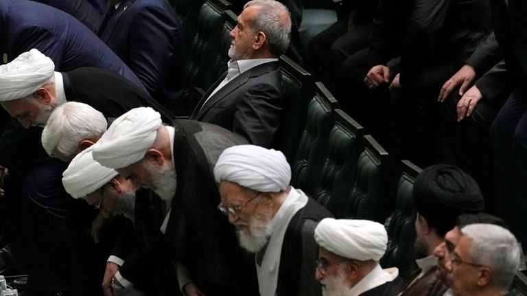 Iran's President Masoud Pezeshkian, top, sits during his swearing-in ceremony...