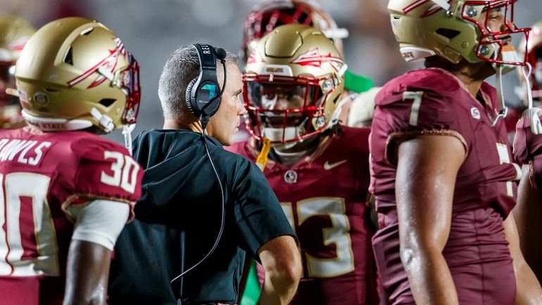 Florida State head coach Mike Norvell, center left, is surrounded...