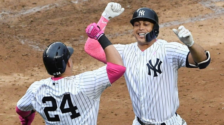 Yankees designated hitter Giancarlo Stanton celebrates with catcher Gary Sanchez...