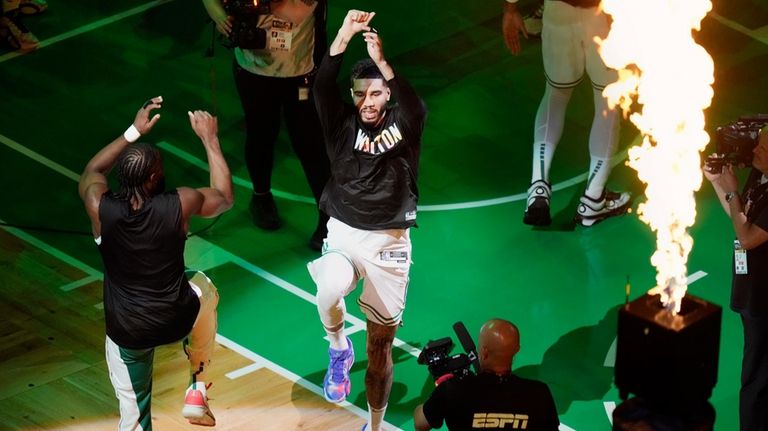 Boston Celtics' Jaylen Brown, left, and Jayson Tatum jump before...