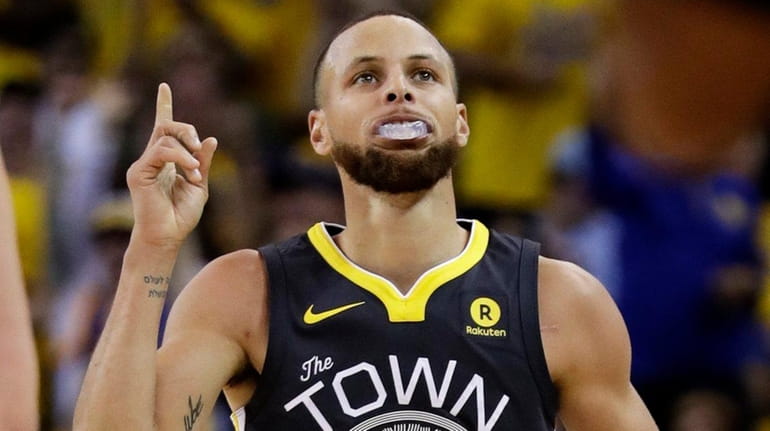 Warriors guard Stephen Curry gestures after scoring against the Cavaliers...