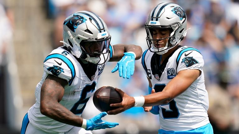 Carolina Panthers quarterback Bryce Young hands off to running back...