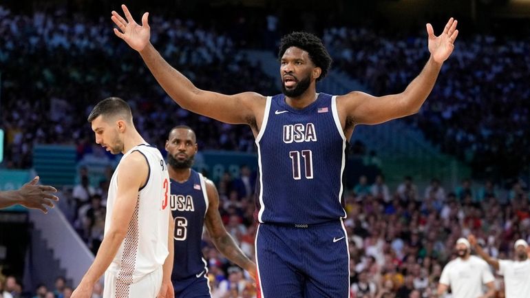 Joel Embiid, right, of the United States, reacts after scoring...