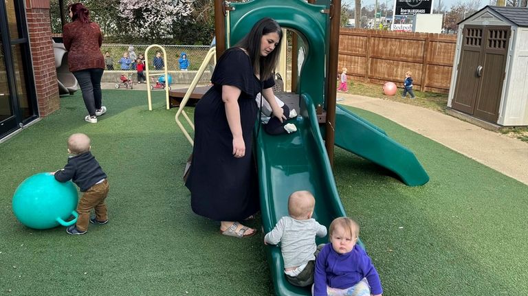 Delaney Griffin, center, plays with toddlers at the child care...