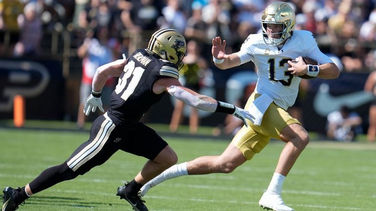 Notre Dame quarterback Riley Leonard (13) tries to get around...