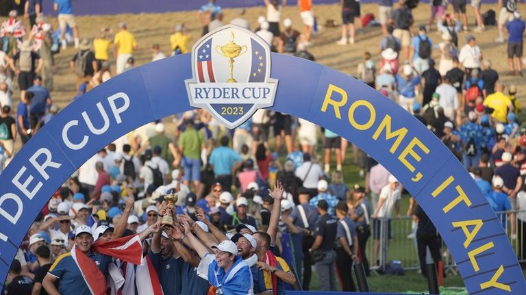 Europe's Team Captain Luke Donald, centre, and team members lift...