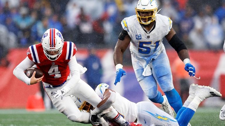 New England Patriots quarterback Bailey Zappe (4) is sacked by...