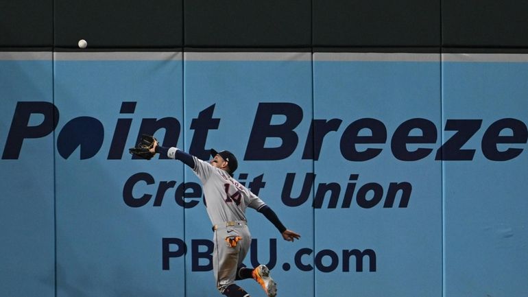 Houston Astros left fielder Mauricio Dubon makes a running catch...