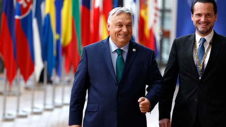 Hungary's Prime Minister Viktor Orban, left, arrives for an EU...