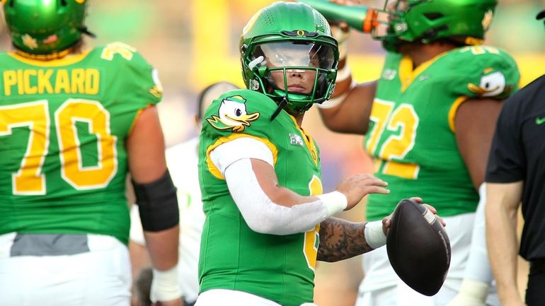 Oregon quarterback Dillon Gabriel warms up before an NCAA college...