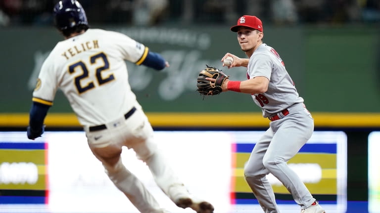 St. Louis Cardinals' Tommy Edman, right, tags Milwaukee Brewers' Christian...
