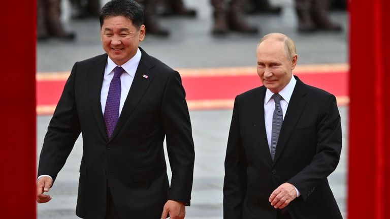 Russian President Vladimir Putin, right, walks with Mongolian President Ukhnaagiin...