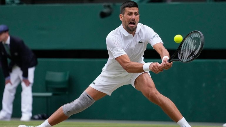 Novak Djokovic of Serbia plays a backhand return to Lorenzo...