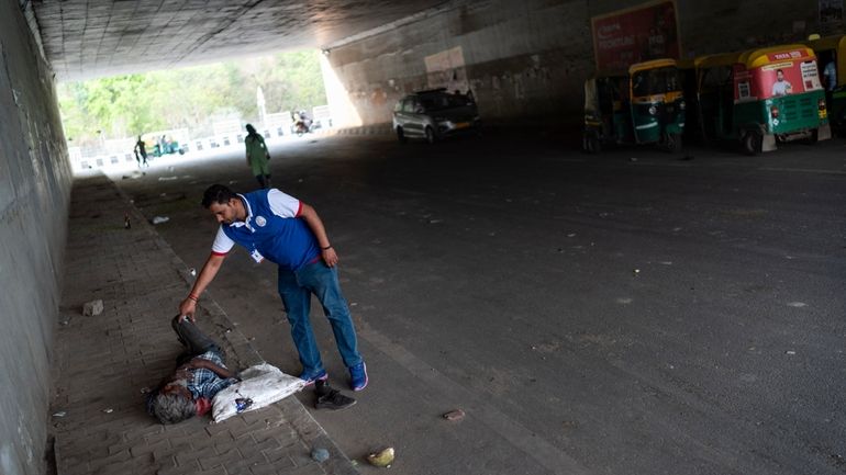 Avanish Kumar, approaches a man living on the street to...