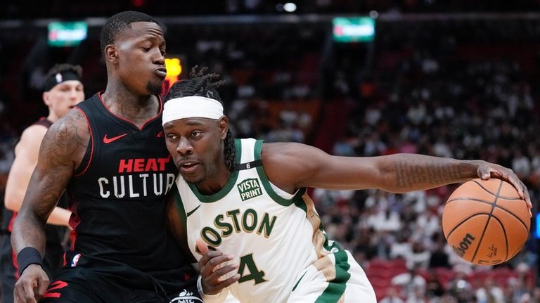 Boston Celtics guard Jrue Holiday (4) drives past Miami Heat...