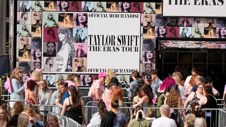 Fans of singer Taylor Swift, called Swifties, arrive at Wembley...