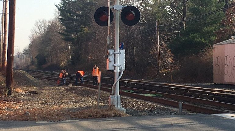 Long Island Rail Road workers inspect the area east of...