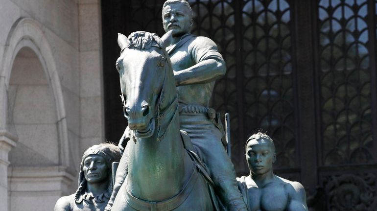 A statue of Theodore Roosevelt on horseback guided by a...