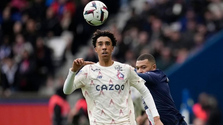 Lille's Leny Yoro controls the ball next to PSG's Kylian...