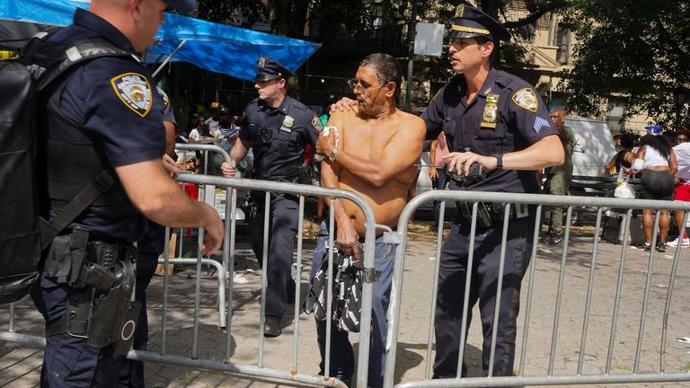 New York police officers escort a man injured during a...