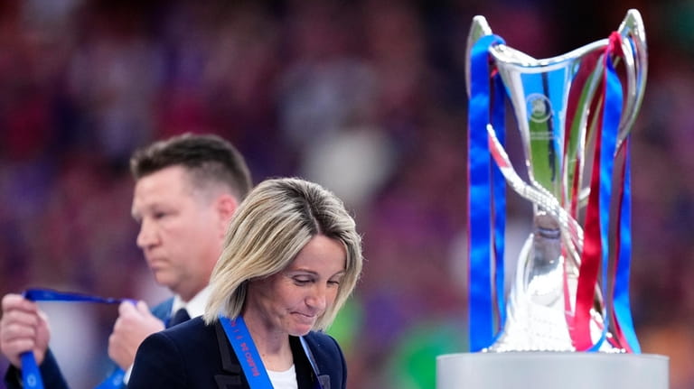 Lyon coach Sonia Bompastor walks past the trophy after receiving...