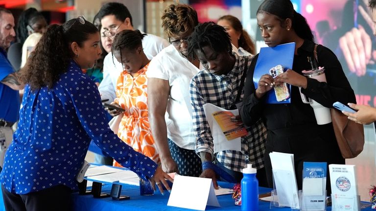 Carolina Wilson, with the United States Postal Service, left, talks...