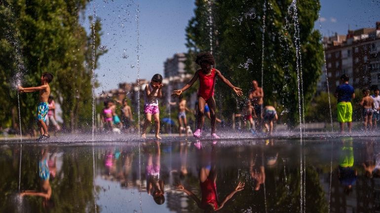 Children cool off at an urban beach at Madrid Rio...