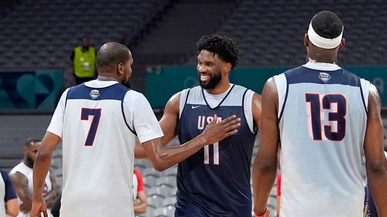 United State's Kevin Durant, left, pats Joel Embiid, center, after...