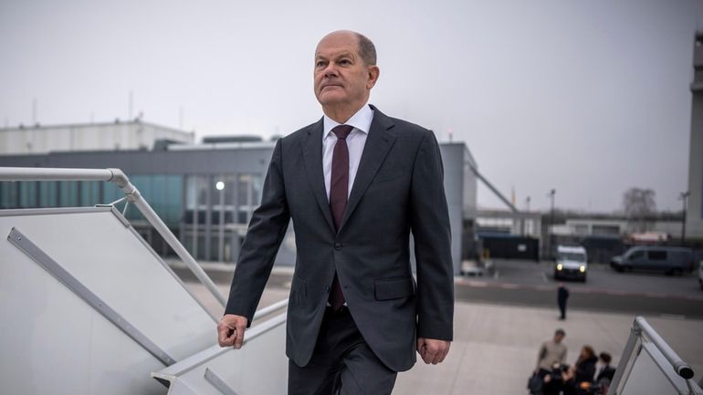 German Chancellor Olaf Scholz boards a plane at the military...