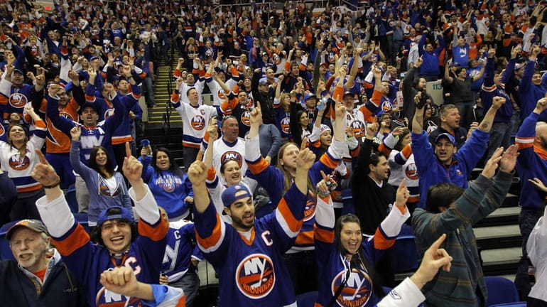 New York Islanders fans cheer after a third-period goal against...