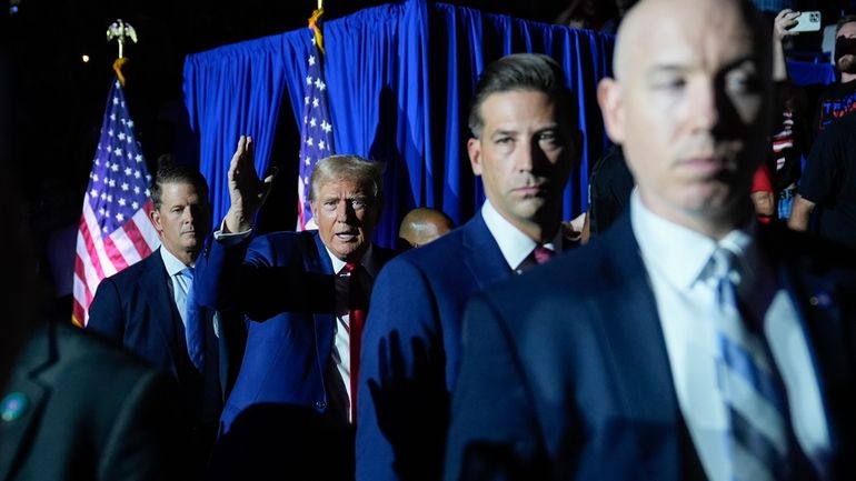 Republican presidential candidate former President Donald Trump, center, gestures as...