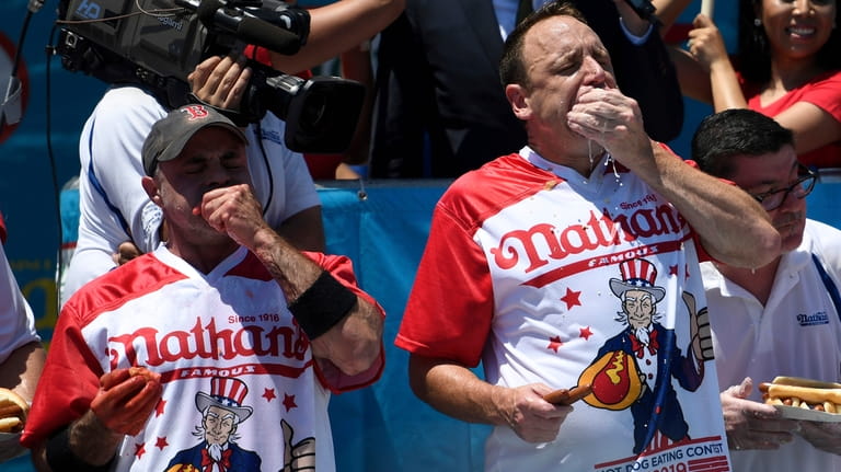 Geoffrey Esper, left, and Joey Chestnut, right, compete during the...