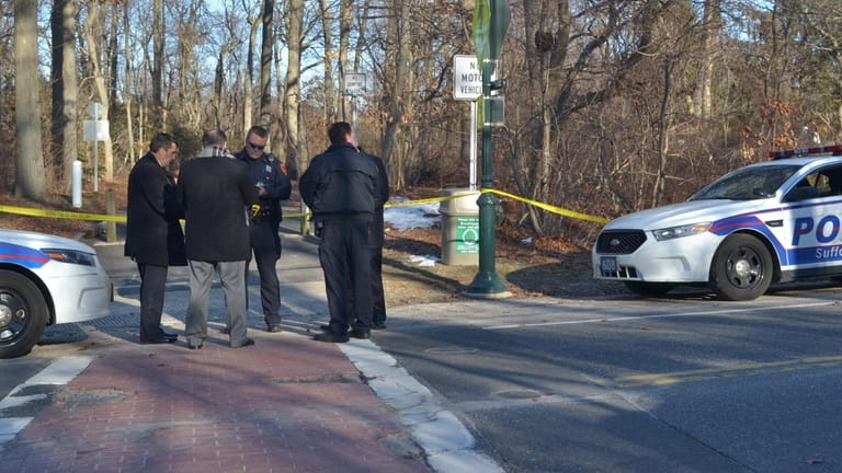 Suffolk homicide detectives gather in front of a walking trail...
