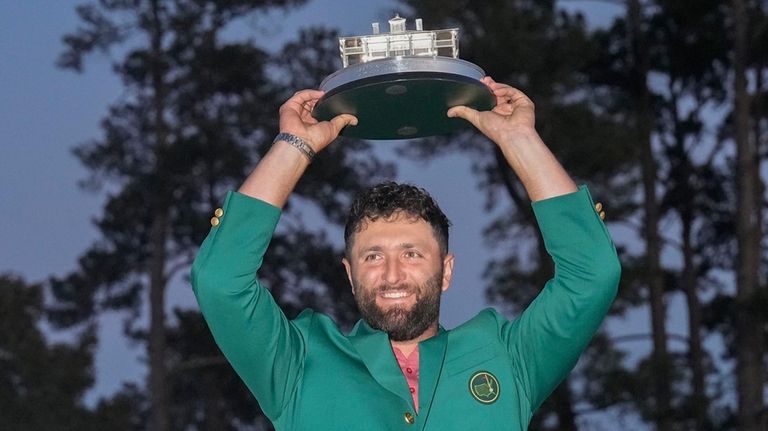 FILE - Jon Rahm, of Spain, holds up the trophy...