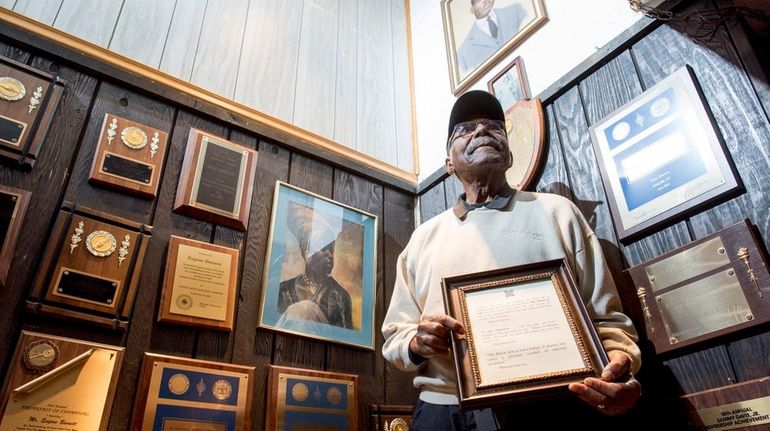 Eugene Burnett displays a plaque given to him by his...