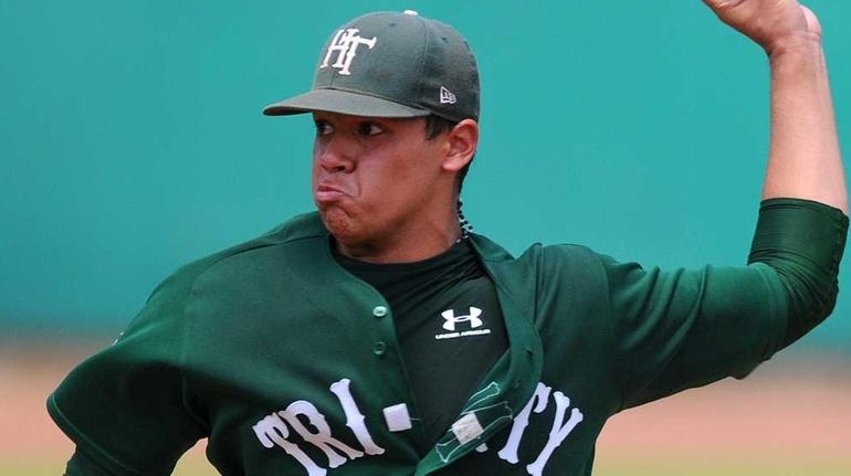 Holy Trinity starting pitcher Alex Robinson delivers to the plate...