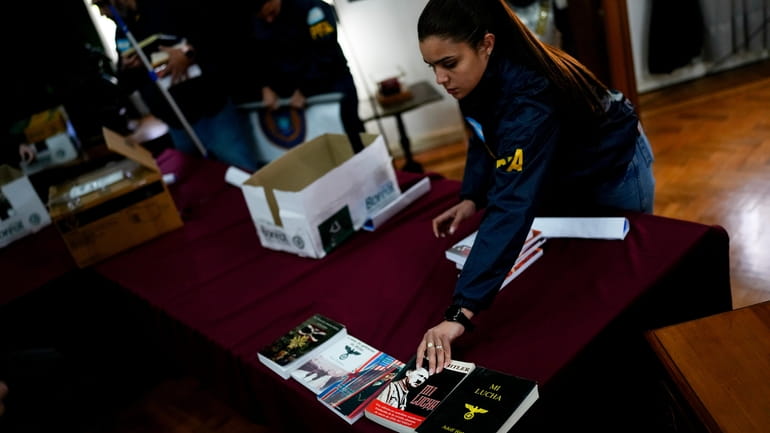 Federal agents put seized books inside boxes after displaying them...