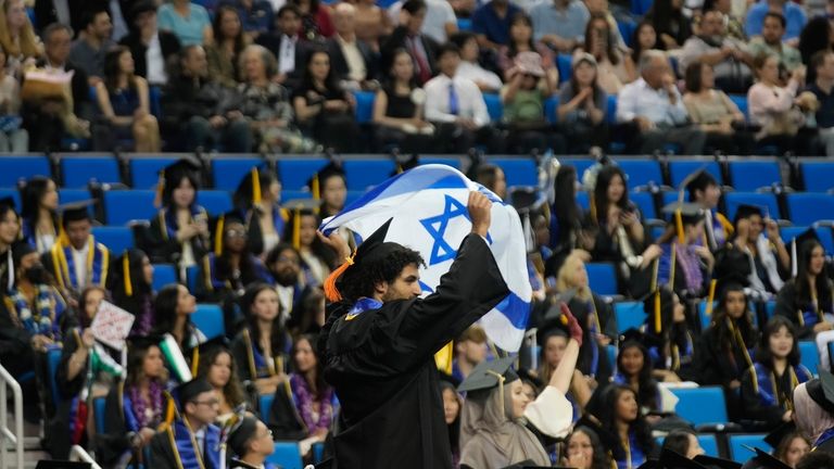 A UCLA graduate waves an Israeli flag during a commencement...