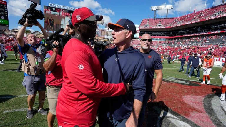 Tampa Bay Buccaneers head coach Todd Bowles, front left, embraces...