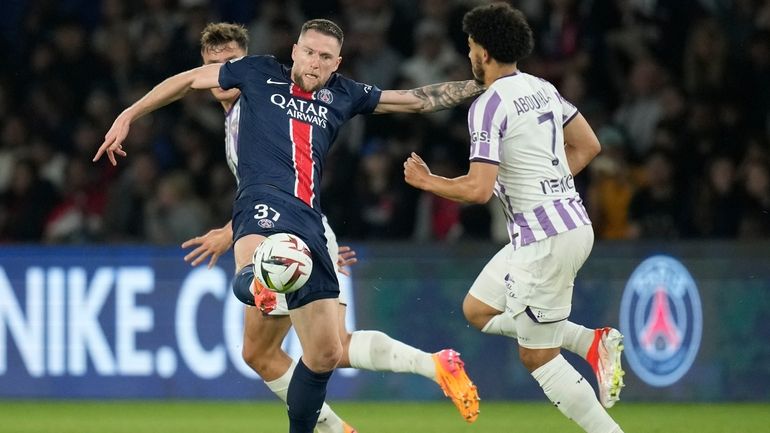 PSG's Milan Skriniar, left, is challenged by Toulouse's Zakaria Aboukhlal...