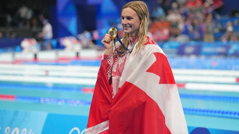 Canada's Summer Mcintosh celebrates winning the gold medal in the...