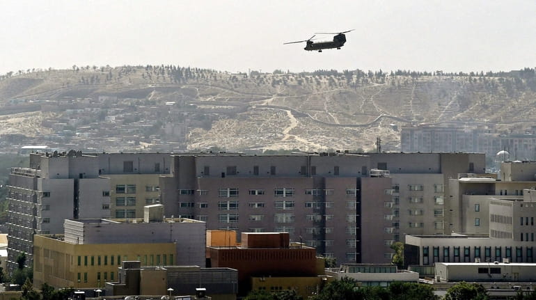 A U.S. military helicopter flies above the U.S. embassy in...
