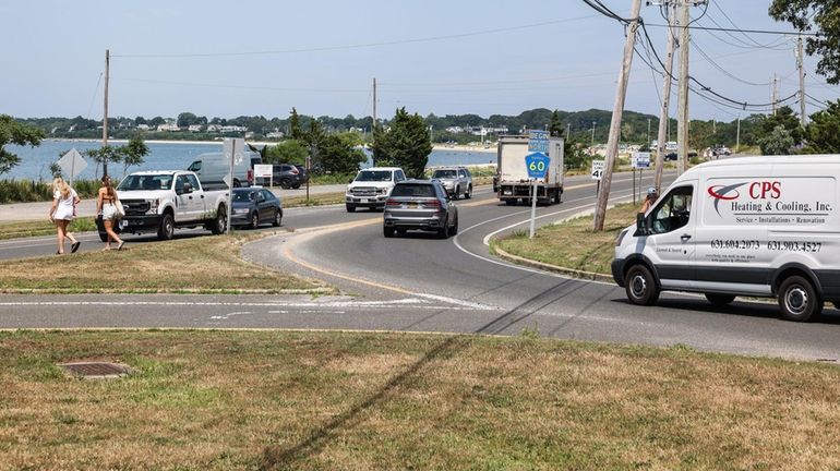 Pedestrians walk near the roundabout at the intersection of Noyack...