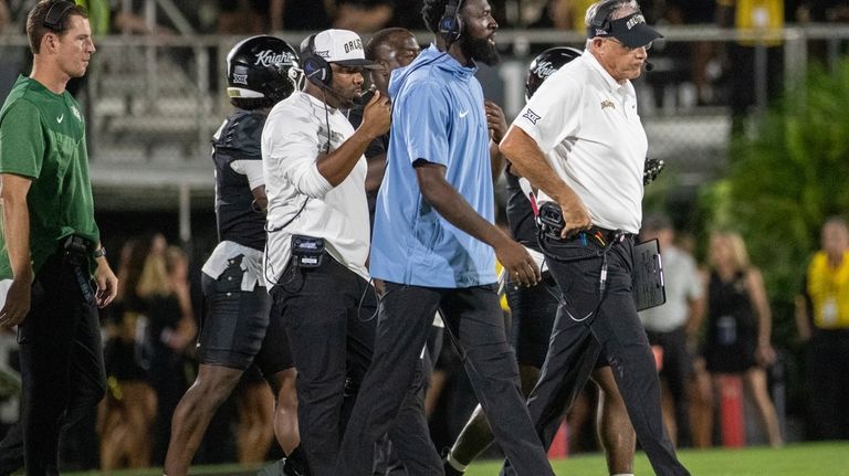 Central Florida head coach Gus Malzahn, right, walks onto the...